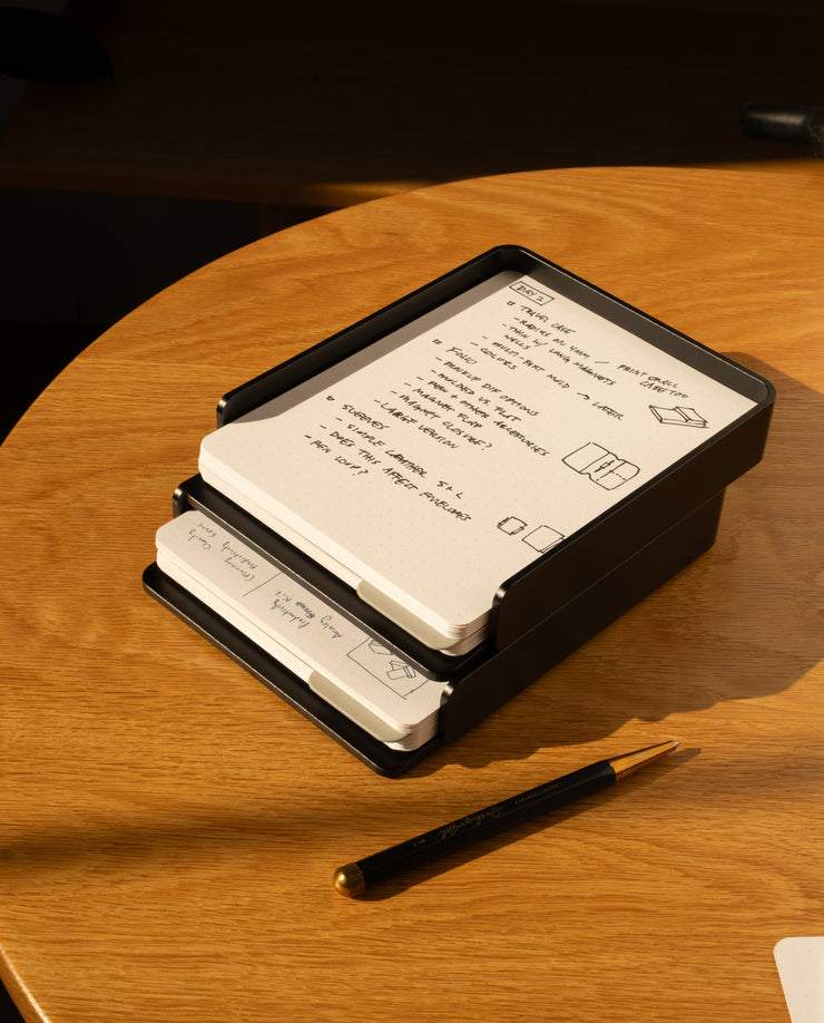 The Analog Capture Kit - 2 Large (Black Aluminum) features dot grid cards in a sleek black aluminum tray, with a pen nearby on a wooden table—everything you need to capture your ideas in style.