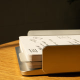 A close-up of the Analog Capture Kit - Large (Silver Aluminum) shows white dot grid cards with sketches and writing, stacked in a sleek silver aluminum tray on a wooden surface under warm light.