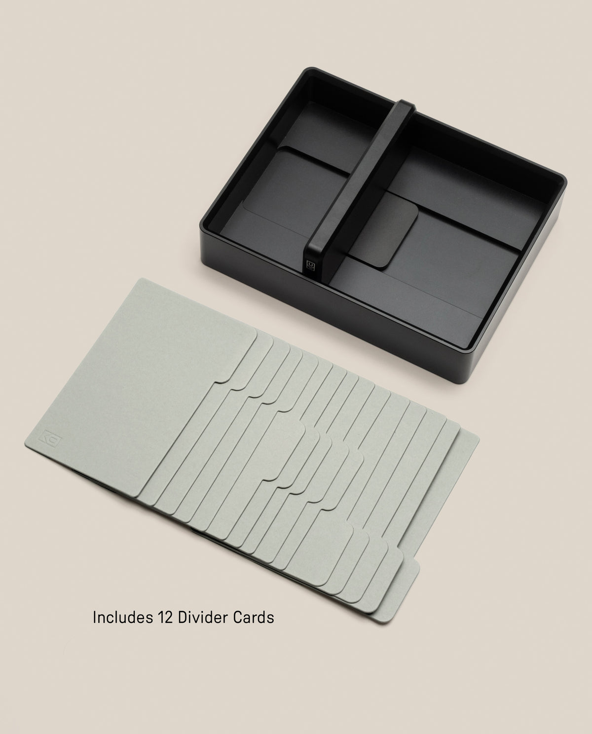 A black solid aluminum Analog Archive card holder with a center divider, positioned above a stack of twelve light-gray desk organizer cards.