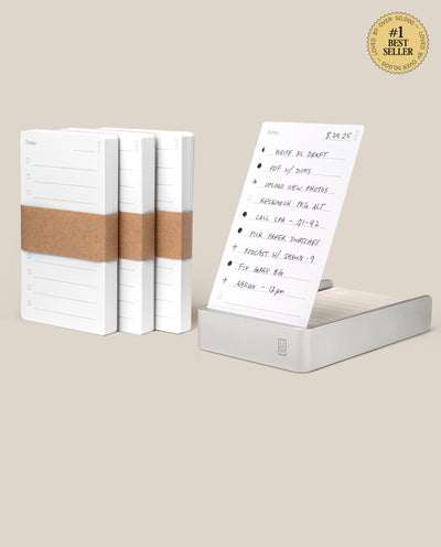 Four stacks of Analog Daily Focus Kit + 3 Refills (Silver Aluminum) task cards—three bundled with brown paper, one in a silver holder showing a handwritten to-do list—display a #1 Best Seller badge in the top right corner.