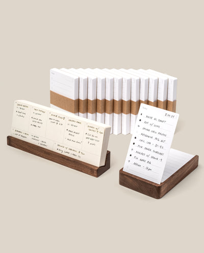 The Analog Annual Kit (Walnut) features white Analog Cards, some shown on walnut Daily Card Holders and others stacked, displaying handwritten notes, lists, and schedules in a minimalist setting with a neutral background.