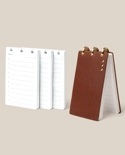 The Leather Discbound Analog + 3 Refills (Brown) stands upright beside three stacks of “Today” refill pages with lined notes and checkboxes—a perfect beige-background setup for analog task cards.