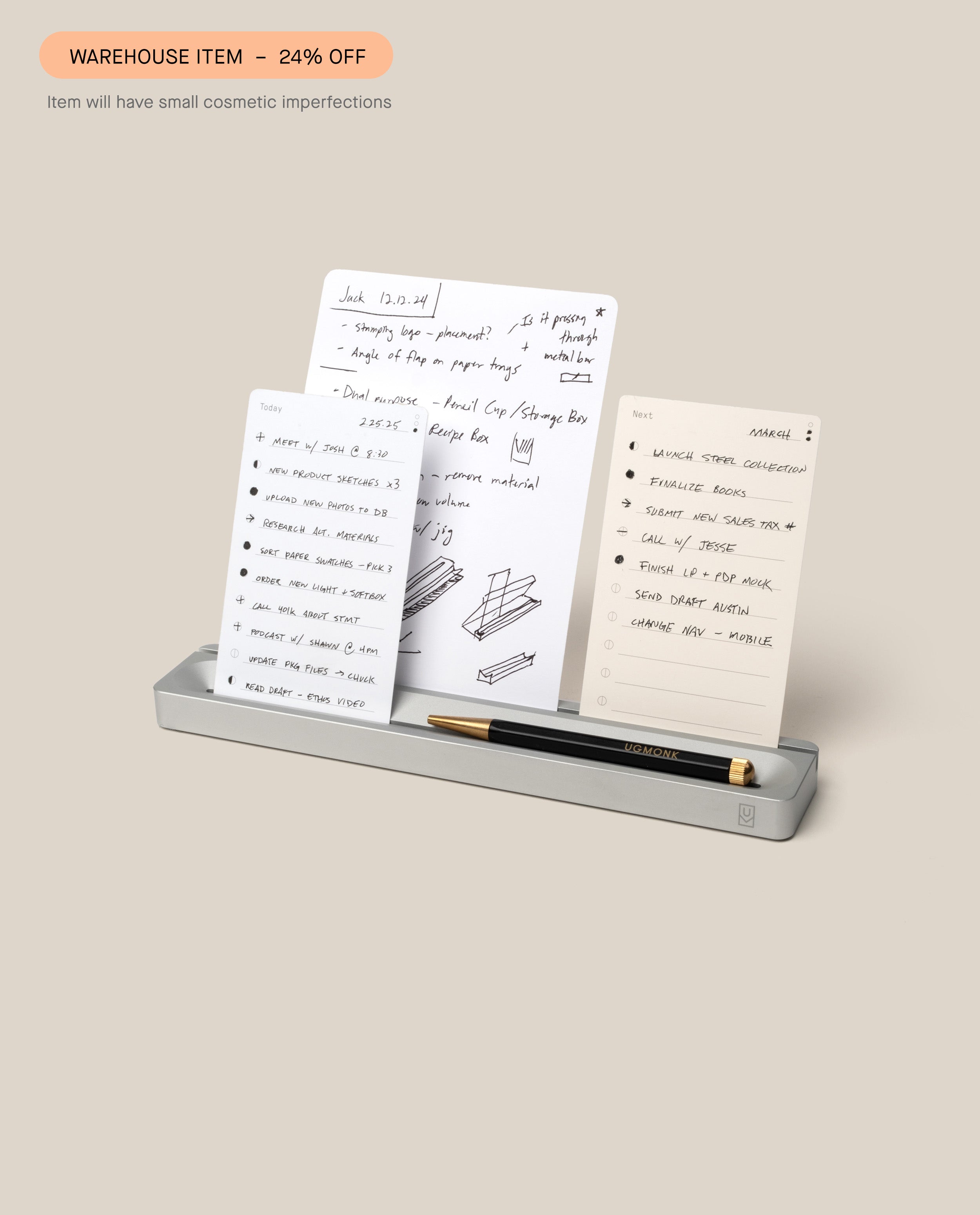 A solid aluminum silver Analog Card Bar (Small 10") holds three white notepads with handwritten notes and a black and gold pen. Text above reads "WAREHOUSE ITEM – 24% OFF" and notes that Warehouse Sale Items may have small cosmetic imperfections.
