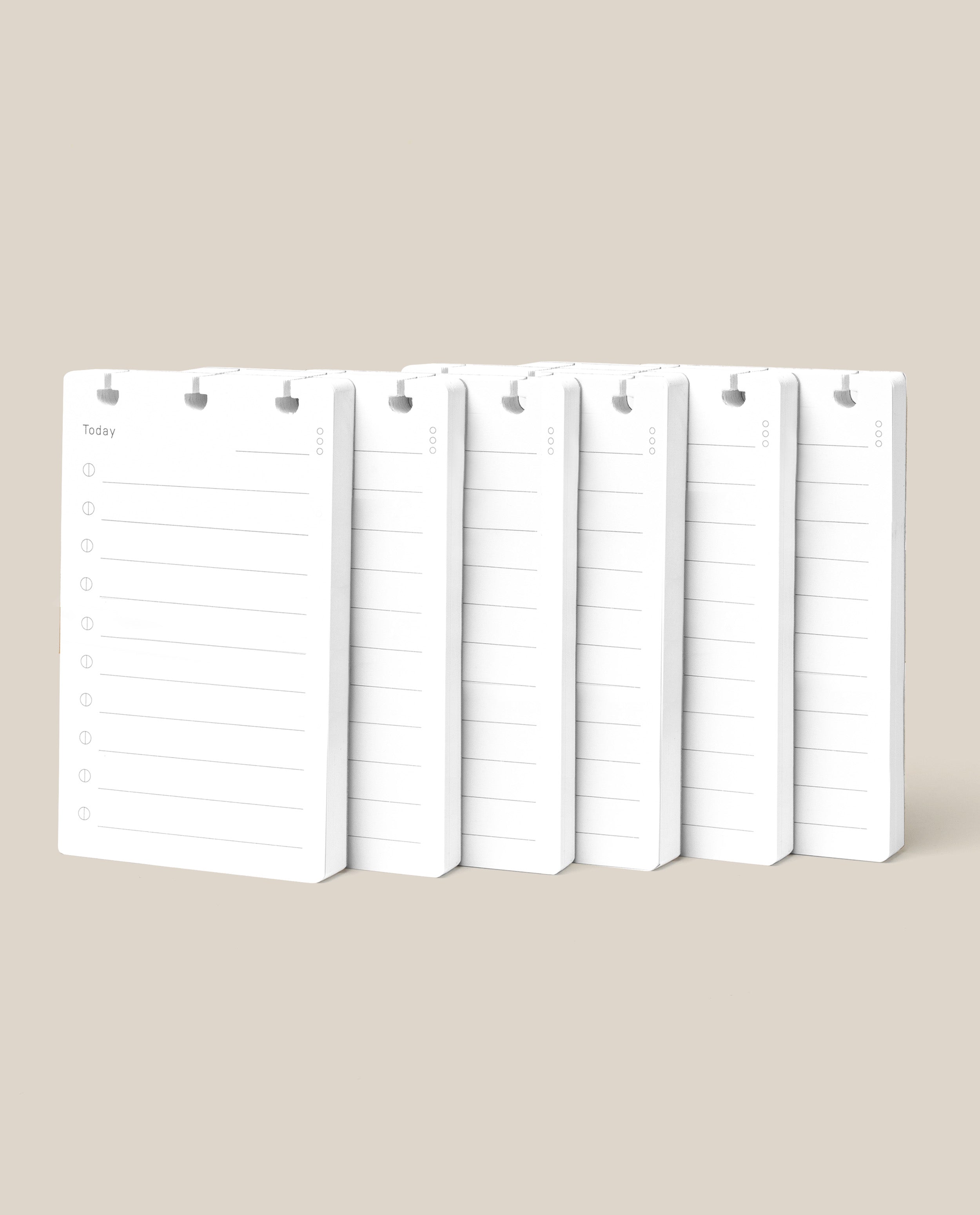 Six white Discbound Analog Refill notepads (6-pack) with blank lines and checkboxes are arranged side by side on a beige background. Each notepad features a top cutout, ideal for hanging, binding, or use as discbound refill cards.