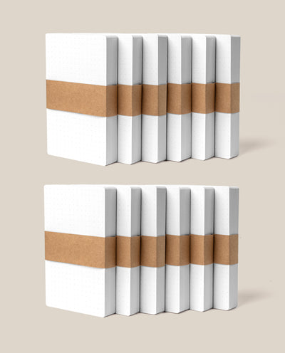 Two rows of Analog Dot Grid Cards (Small - 12-Pack) with dotted covers are bundled in brown paper bands, made from thick uncoated cardstock and displayed on a neutral background.