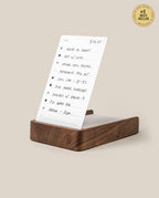 The Analog Daily Focus Kit (Walnut) stands upright on a wooden base like a card holder, displaying handwritten to-do lists with checkboxes. A #1 Best Seller gold badge appears at the top right on a beige background.