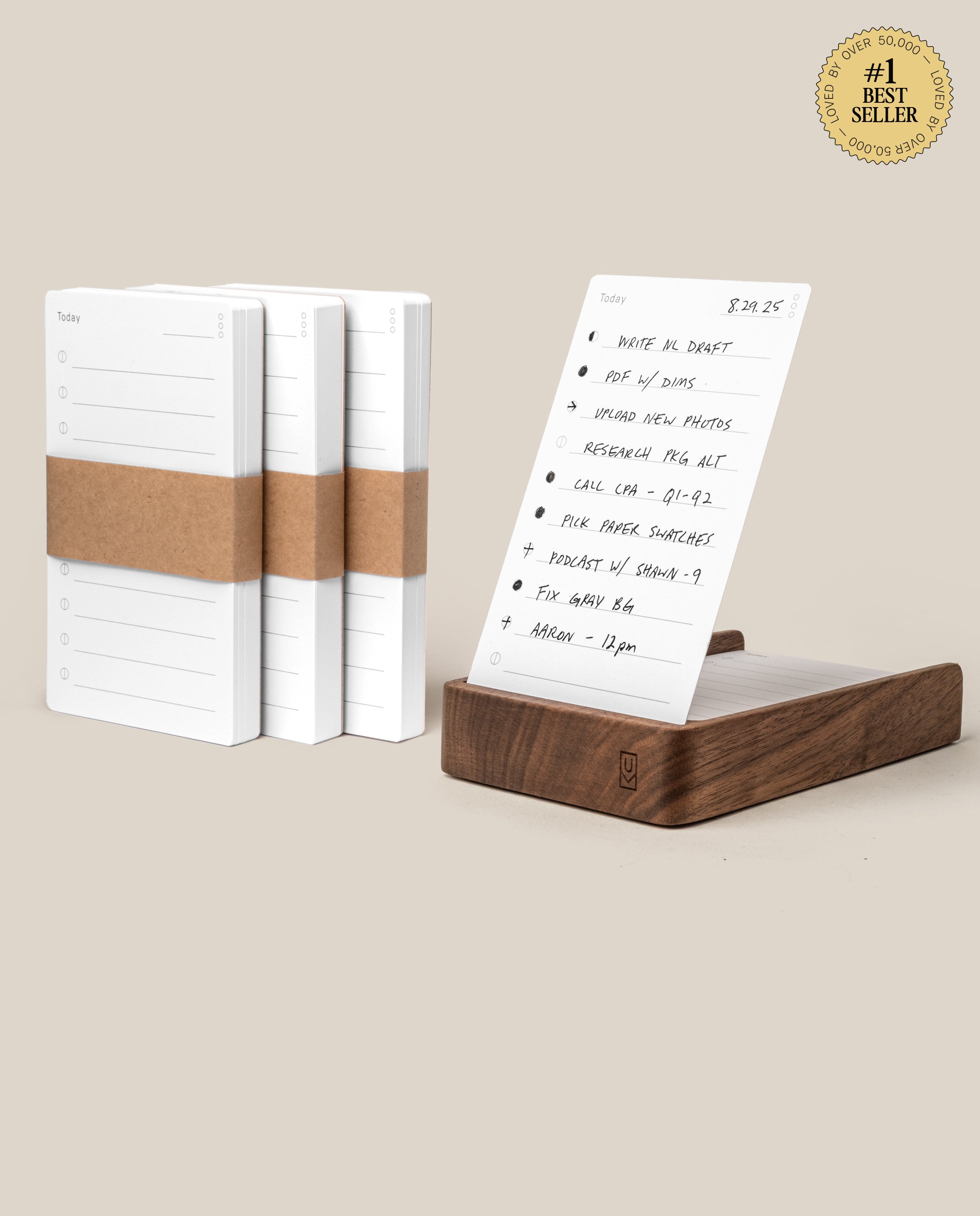 The Analog Daily Focus Kit + 3 Refills (Walnut) features three notepad stacks with brown paper bands and a walnut card holder displaying a daily sheet on a beige background. #1 Best Seller—your ideal analog productivity system.