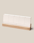 The Analog Weekly Planning Kit (Maple) features seven labeled Weekly Planner Cards—one for each day—displayed on a sleek maple stand against a simple beige background.
