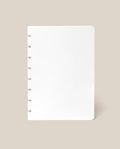 A Discbound Journal Refill - Blank (Standard 6″ x 8.5″) with six silver rings along the left edge, reminiscent of an Heirloom Discbound Journal, is centered on a beige background.