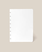 A Discbound Journal Refill - Blank (Standard 6″ x 8.5″) with six silver rings along the left edge, reminiscent of an Heirloom Discbound Journal, is centered on a beige background.