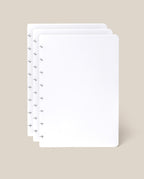 Three blank, white Discbound Journal Refill pages (Standard 6″ x 8.5″)—perfect for adding to your Heirloom Discbound Journal—are stacked together with visible mushroom-shaped holes on the left edge, displayed against a light beige background.