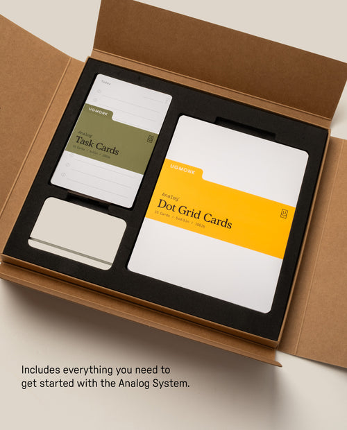 The Analog Starter Kit (Silver) comes as a boxed set including Ugmonk Analog Task Cards, Dot Grid Cards, and blank cards, all designed to help you organize tasks with a streamlined paper card system. Text reads: Includes everything you need to get started with the Analog System.