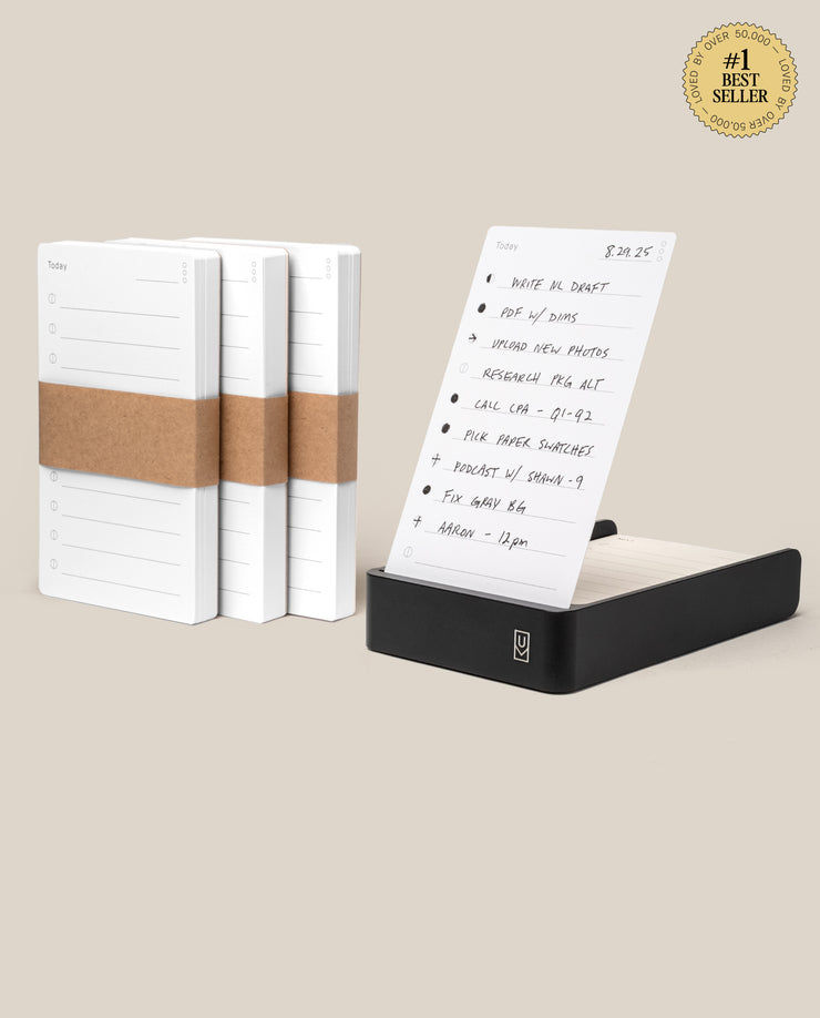 The Analog Daily Focus Kit + 3 Refills (Black Aluminum) includes three notepads wrapped in brown paper next to a black aluminum card holder showing a handwritten to-do list, with a #1 Best Seller badge in the top right corner.