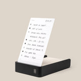 The Analog Daily Focus Kit (Black Aluminum) holds a handwritten to-do list on a white task card with tasks, times, and checkboxes, set against a beige background—ideal for organizing your productivity system.