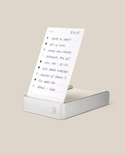The Analog Daily Focus Kit (Silver Aluminum) is a minimalist productivity system with handwritten task cards for reminders like writing, uploading photos, making calls, and recording podcasts in a sleek aluminum card holder.