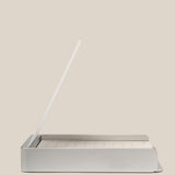 The Analog Daily Focus Kit + 6 Refills (Silver Aluminum) is a minimalist desk organizer that holds a notepad and white pencil upright, keeping task cards tidy on your workspace, shown against a plain beige background.