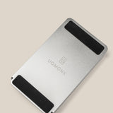 The Analog Annual Kit (Silver Aluminum) features a sleek rectangular metal stand with two black grips and "UGMONK" engraved in the center, ideal as a Weekly Card Holder, shown on a beige background.