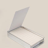 The Analog Daily Focus Kit + 6 Refills (Silver Aluminum) features a sleek, hinged aluminum card holder with lined task cards for notes and checkboxes—an elegant productivity tool displayed on a light beige surface.