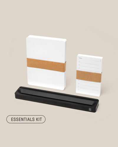 The Analog Card Bar - Essentials Kit (Black Aluminum) features two white notepads with brown bands, a sleek black aluminum card bar, and dot grid cards, all presented against a light beige background.