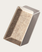 The Gather 2x2 Organizer Set (White) features a rectangular, customizable desk organizer with white powder-coated steel sides and a textured light brown base, shown on a light surface casting a sharp shadow to the right.