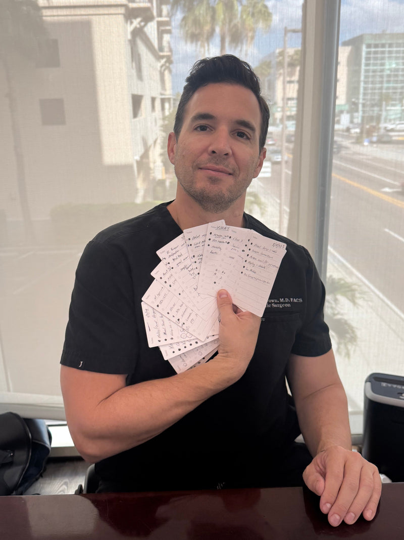 Man holding cards in front of a window with a cityscape view