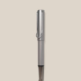 A graphite LAMY AL-star Rollerball with a sleek design stands vertically against a light beige background, highlighting its smooth writing performance and stylish, refillable rollerball pen construction.