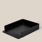 A black, rectangular aluminum card tray with low sides and a front cutout sits on a beige background—ideal for organizing large dot grid cards from the Analog Capture Kit - Large (Black Aluminum).