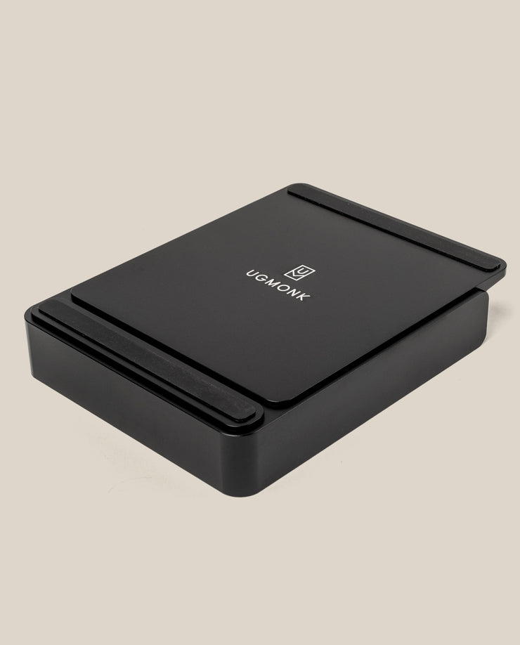 A black rectangular Analog Capture Kit - Small & Large (Black Aluminum) desktop organizer with rounded edges and the Ugmonk logo and name on top, set against a plain beige background.