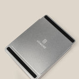 The Analog Capture Kit - Small & Large (Silver Aluminum) is a rectangular metal laptop stand with black non-slip strips at both ends and the UGMONK logo centered, matching the minimalist Dot Grid Cards, shown on a plain beige background.