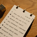 Notebook with handwritten to-do list on a wooden surface