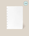 A Discbound Journal Refill - Lined (Standard 6″ x 8.5″) page, featuring white paper with disc-bound holes along the left edge and neat lines, is centered on a beige background. Designed as refill paper for your Heirloom Discbound Journal, each page includes a blue circle in the top right corner labeled “Lined.”.