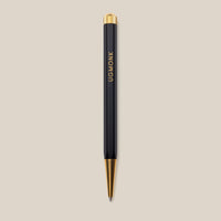 A Ugmonk Pen (Leuchtturm1917 Drehgriffel - Black) with gold accents and UGMONK in gold lettering on the barrel, shown against a plain beige background.