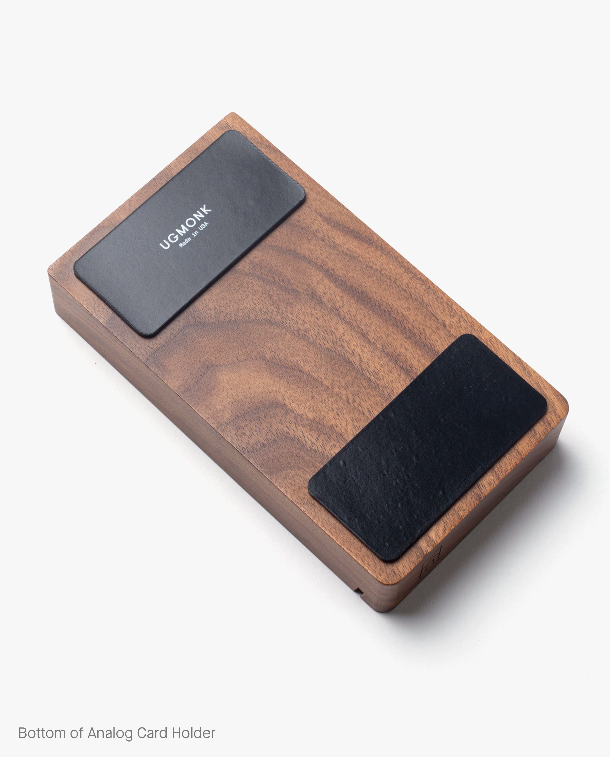 The Magnet Kit (For Analog Card Holder) includes two black adhesive magnets with the Ugmonk logo, designed for use on the underside of your rectangular wooden card holder. Featured against a white background.