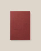 A maroon Layflat Notebook with rounded corners and an embossed geometric cover design, displayed on a light beige background.