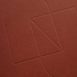 Embossed geometric shapes—a rectangle, triangle, and two semicircles—are outlined on the textured cover of the maroon Layflat Notebook.