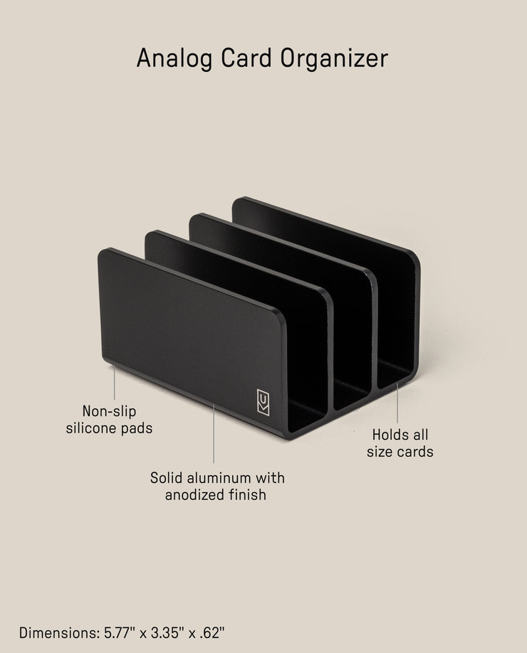 The Analog Card Organizer (Black Aluminum) is a three-slot card tray with non-slip silicone pads, made from solid anodized aluminum. It fits all card sizes and measures 5.77 x 3.35 x 0.62 inches.