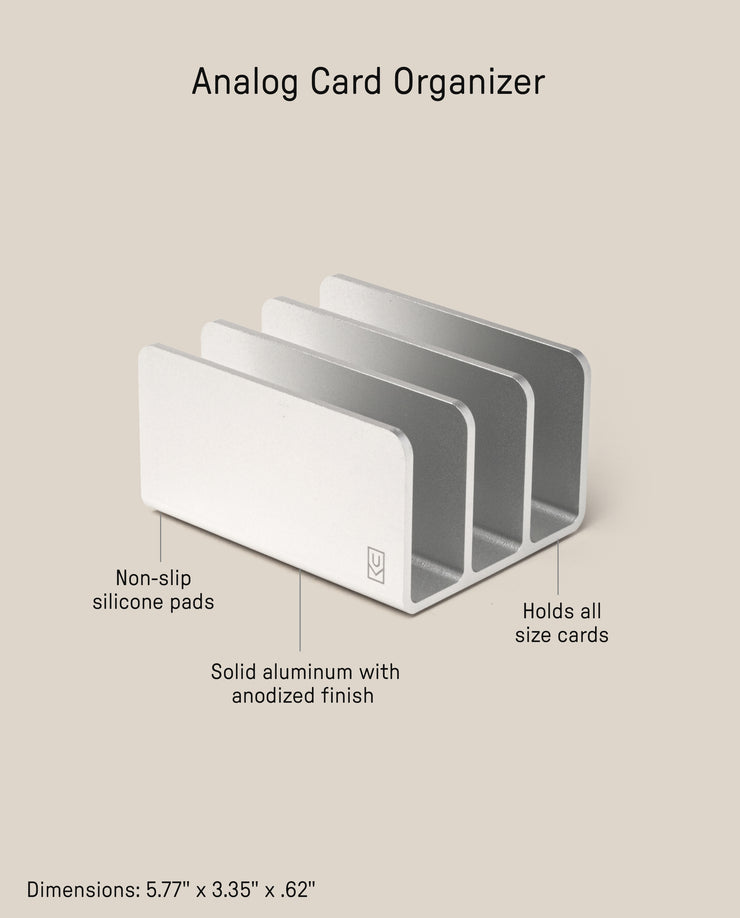 The Analog Card Organizer (Silver Aluminum) is a sleek organizer with three slots, crafted from anodized solid aluminum. It features non-slip silicone pads, ample card storage, and measures 5.77 x 3.35 x 0.62 inches.