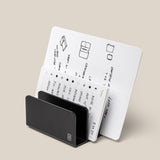 The Analog Card Organizer (Black Aluminum) displays multiple white cards with handwritten notes, diagrams, and sketches arranged in rows against a plain beige background.
