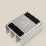 The Complete Analog Collection (Silver Aluminum) desktop organizer features three slots, two black non-slip pads, and the UGMONK logo on its surface, shown against a beige background.