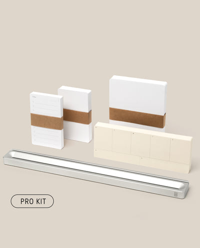 The Analog Card Bar - Pro Kit (Silver) features neatly arranged stationery: notepads with brown bands, a metal tray, weekly cards, and a PRO KIT button, all displayed on a light beige background.