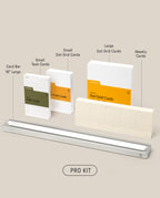 A neatly arranged productivity kit, the Analog Card Bar - Pro Kit (Silver), holds small and large Task Cards, Dot Grid Cards, and weekly cards—all labeled and standing upright on a beige background.