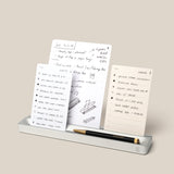 The Analog Card Bar (Small 10" - Silver) stylishly displays three white notecards with handwritten ideas. A black and gold pen sits in front, serving as a sleek pen tray. Text reads: *Cards sold separately.