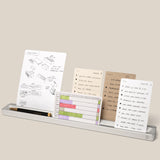The Analog Card Bar (Large 16" – Silver) is a minimalist solid aluminum desk organizer that holds several task cards featuring sketches, lists, and charts, as well as a black pen and gold pencil. *Cards sold separately.