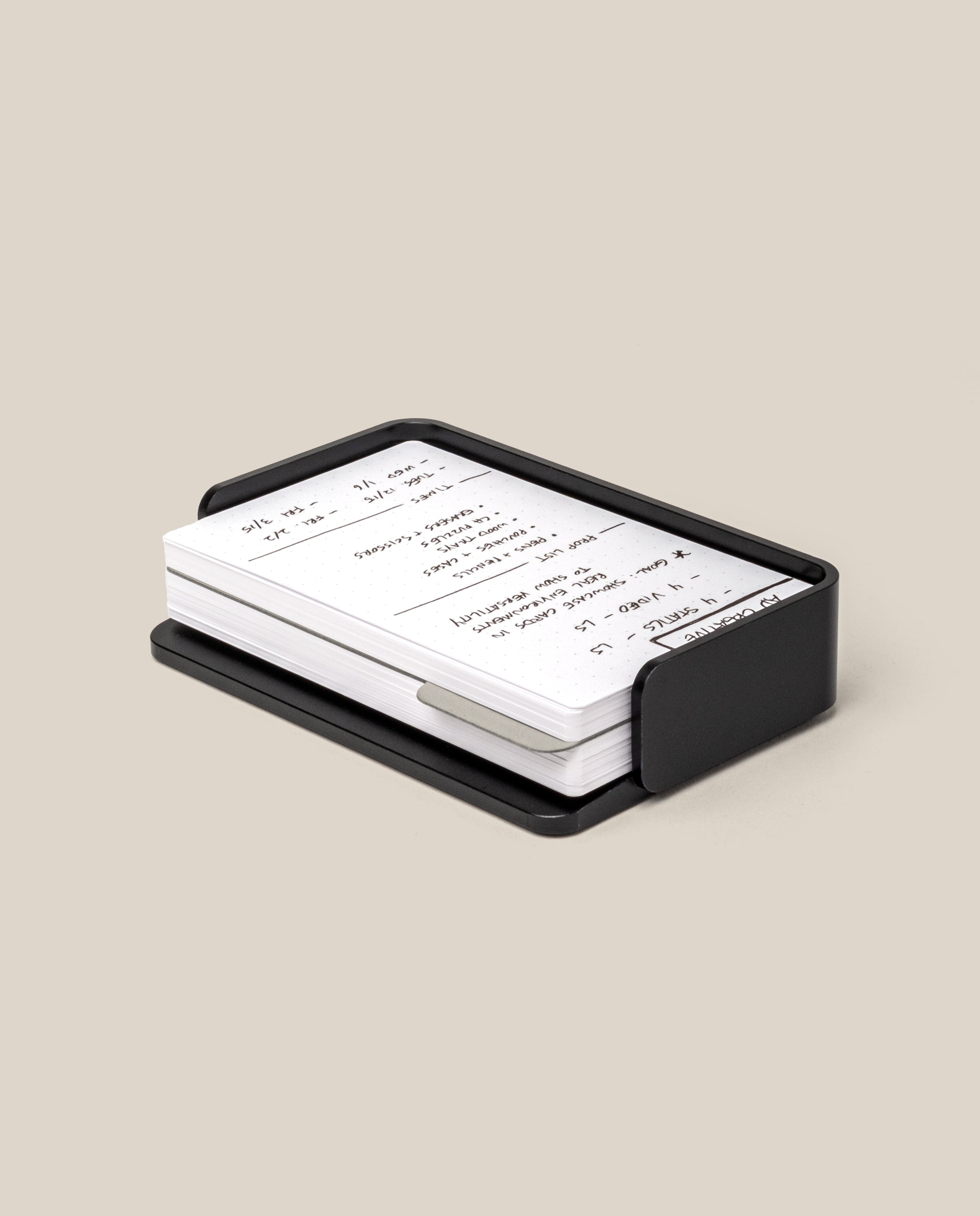 The Complete Analog Collection (Black Aluminum): a black metal organizer holding white index cards with handwritten notes, displayed on a neutral beige background.