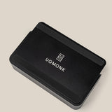 A black rectangular card organizer with rounded edges, featuring the UGMonk logo and name in white, set on a beige background—part of The Complete Analog Collection (Black Aluminum).