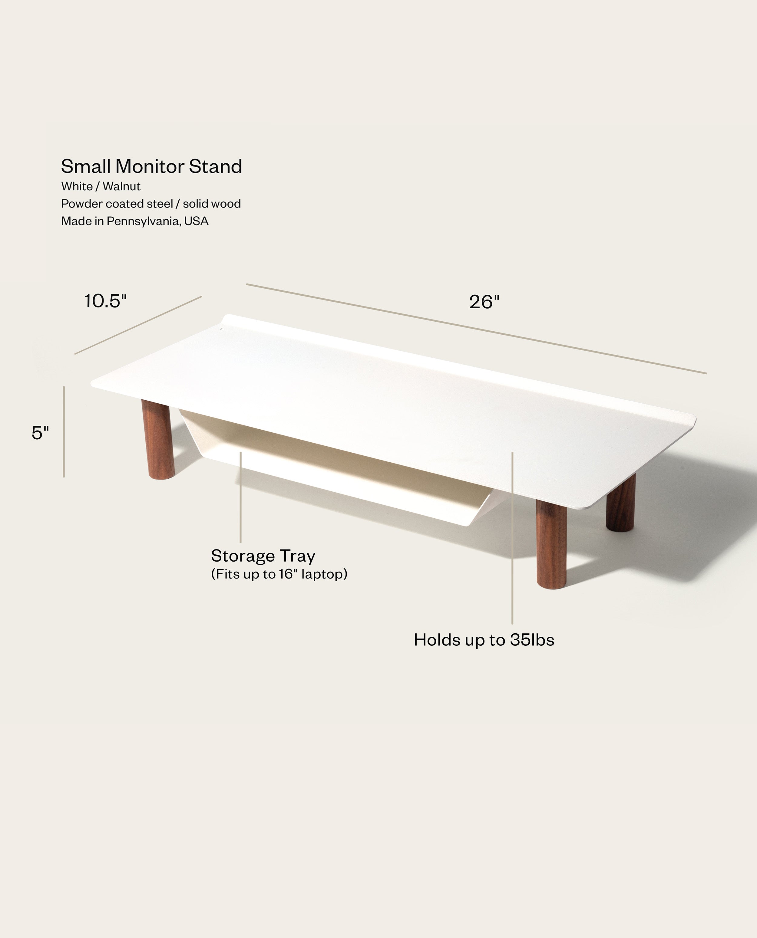 The Gather Small Monitor Stand (White/Walnut) is a space-saving desk organizer with a storage tray, measuring 26" x 10.5" x 5". Made from powder-coated steel and solid wood, it fits laptops up to 16" and supports up to 35 lbs.