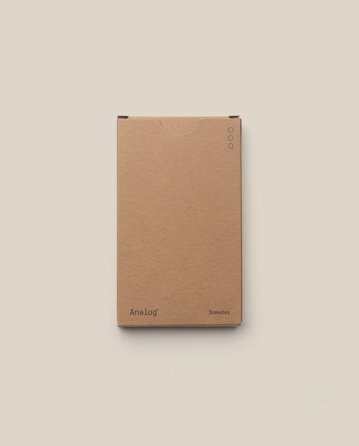 A plain brown box labeled "Analog" (bottom left) and "Someday" (bottom right), shown on a light beige background, features three small circles top right—ideal for storing your Analog - Someday Cards (1-Pack).