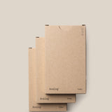 Three stacked brown cardboard boxes of the Analog - Today Cards (3-Pack) sit against a plain beige background, with “Analog” and “Today” on the lower corners and minimalist circle details in the upper right.