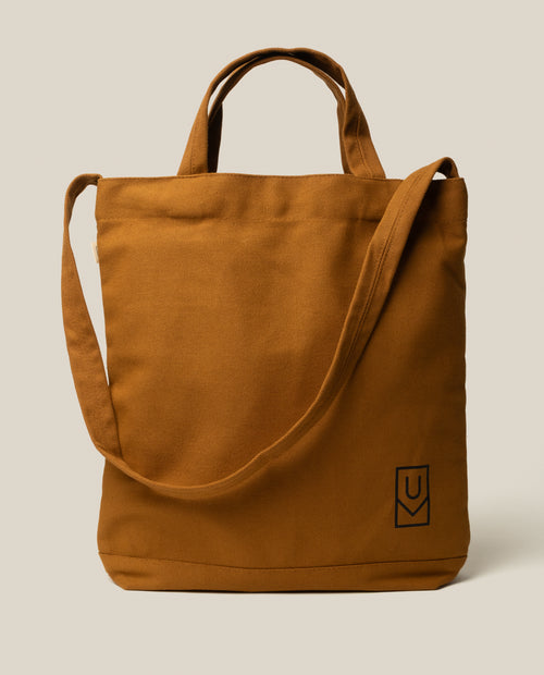 Utility Tote Bundle - Set of 3: A durable brown canvas tote bag with dual top handles, a shoulder strap, and a small square logo in the bottom corner.