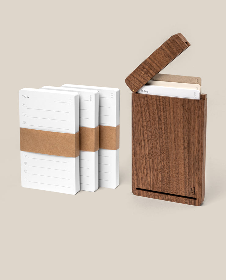 The Analog Travel Case + 3 Card Packs (Walnut) includes a premium walnut wood case with a hinged lid and three extra card packs, perfect for organizing your cards at home or on the go.